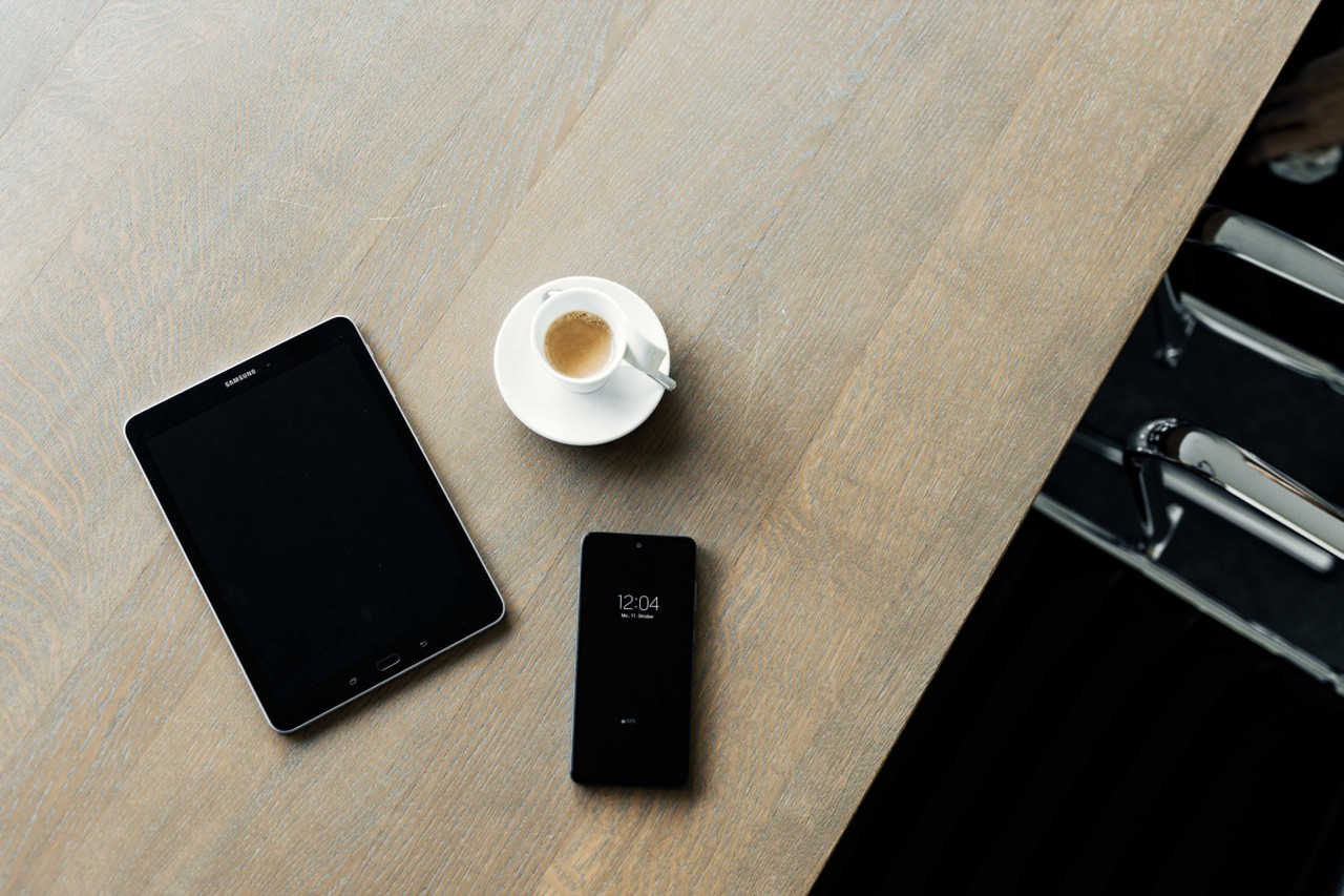 Tablet, Telefon, Kaffee auf dem Schreibtisch